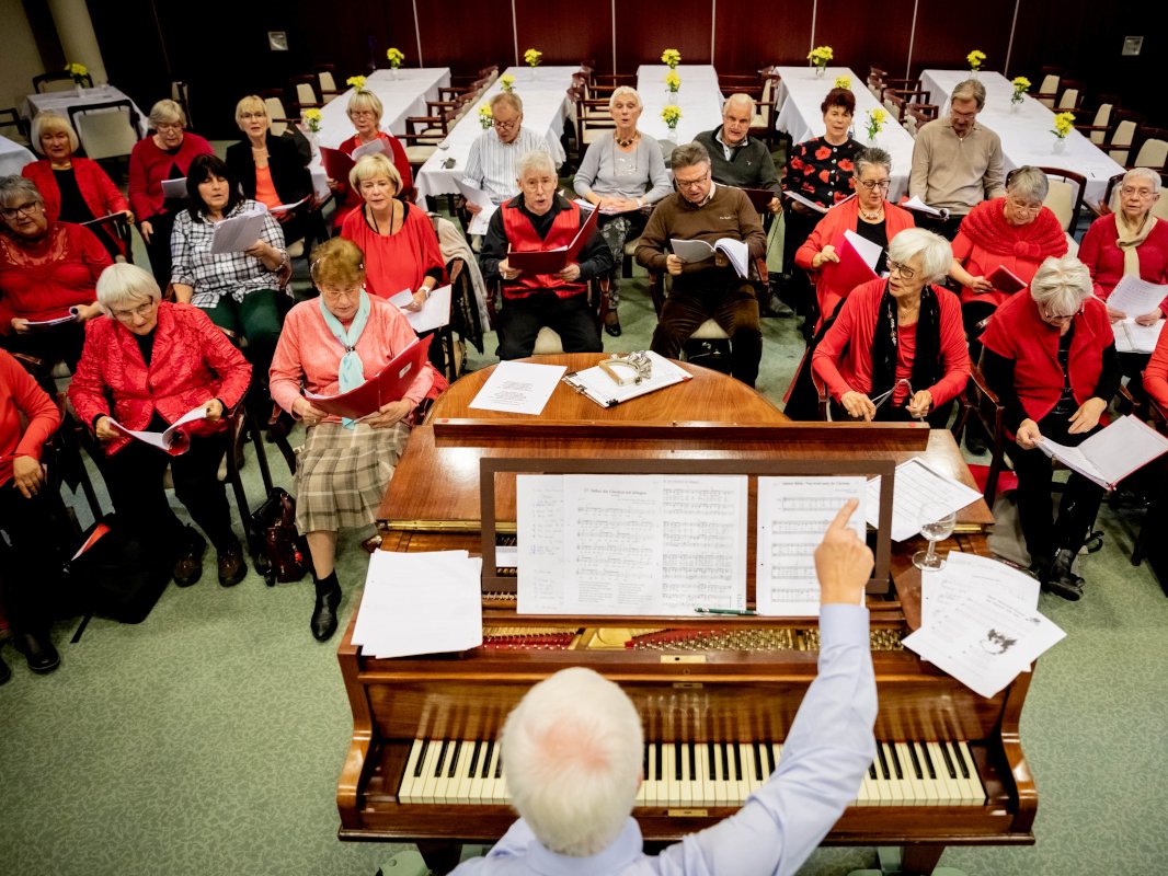 Chor bei einer Probe mit Chorleitung am Klavier.